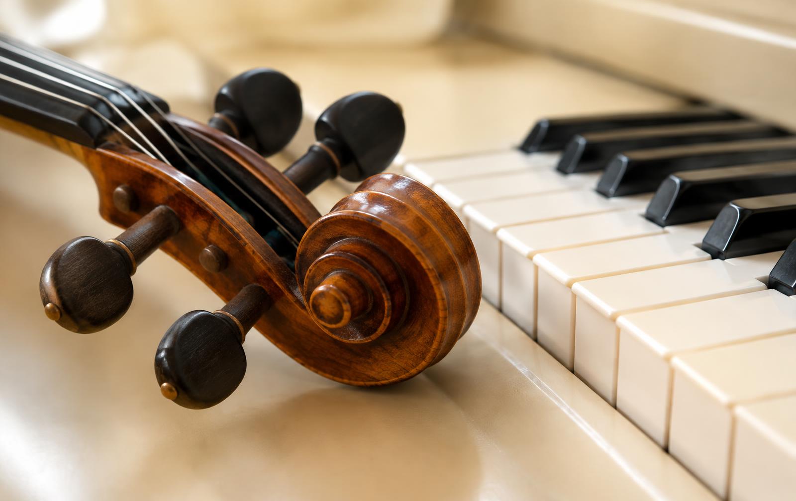 JMI violin scroll resting on piano keys